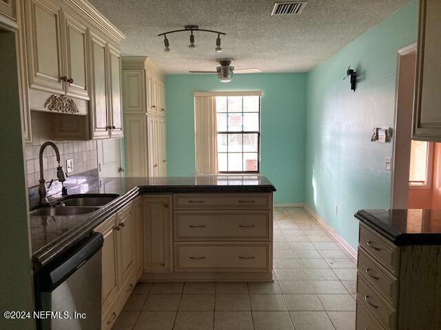 kitchen with kitchen peninsula, backsplash, stainless steel dishwasher, ceiling fan, and sink