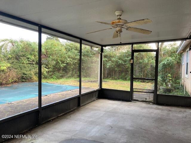 unfurnished sunroom with ceiling fan