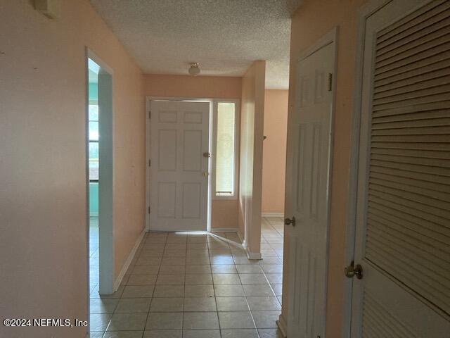 tiled foyer entrance with a textured ceiling