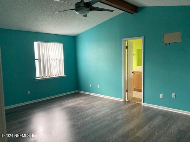 empty room with lofted ceiling with beams, dark hardwood / wood-style floors, a textured ceiling, and ceiling fan