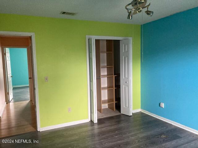 unfurnished bedroom featuring dark hardwood / wood-style floors and a closet