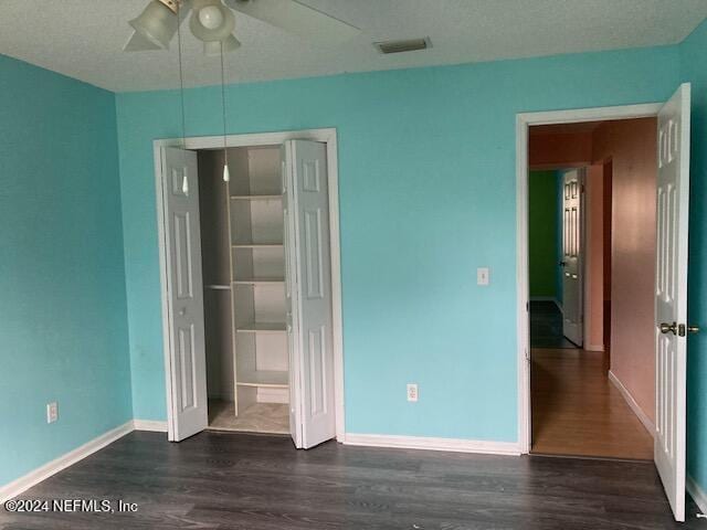 unfurnished bedroom featuring a closet, ceiling fan, and dark hardwood / wood-style floors