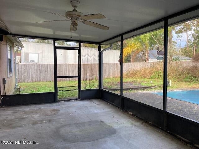 unfurnished sunroom featuring ceiling fan