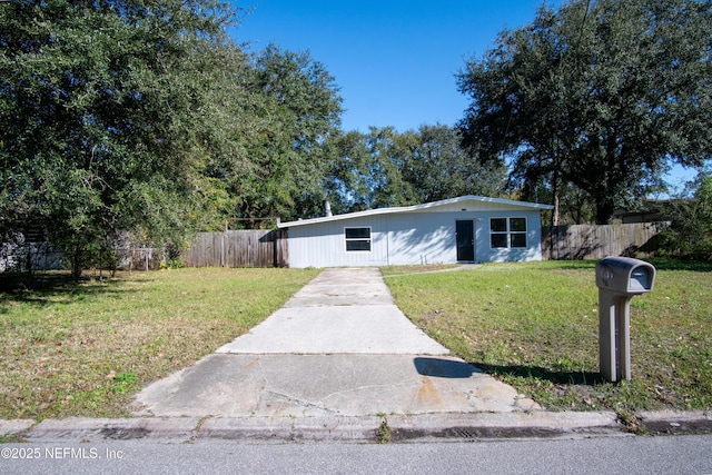 view of front of house featuring fence and a front yard