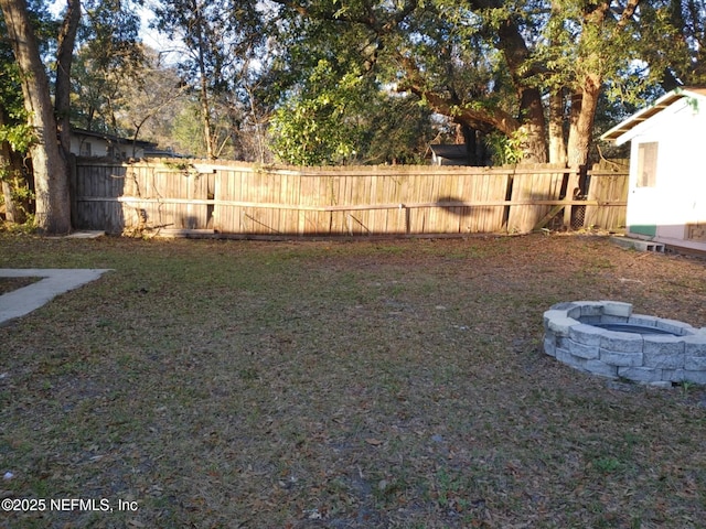 view of yard featuring fence and a fire pit