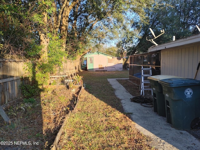 view of yard with an outbuilding, a storage shed, and a fenced backyard