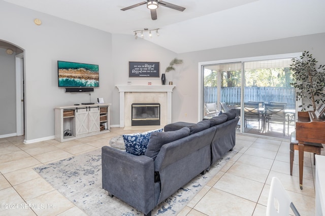 tiled living room featuring ceiling fan, a premium fireplace, and lofted ceiling