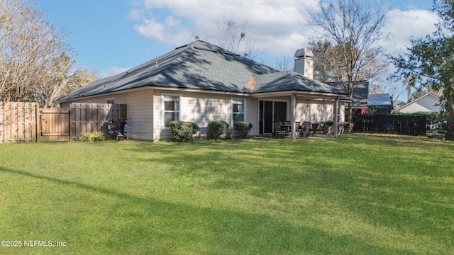 back of house with a lawn