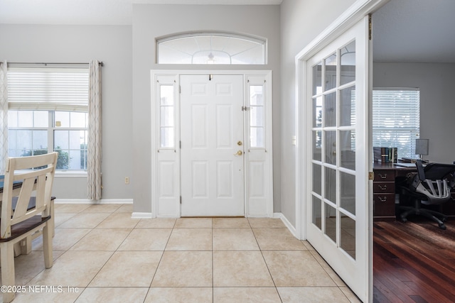 foyer featuring french doors and light tile patterned flooring