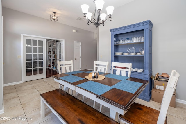 dining room featuring french doors, light tile patterned floors, and a notable chandelier