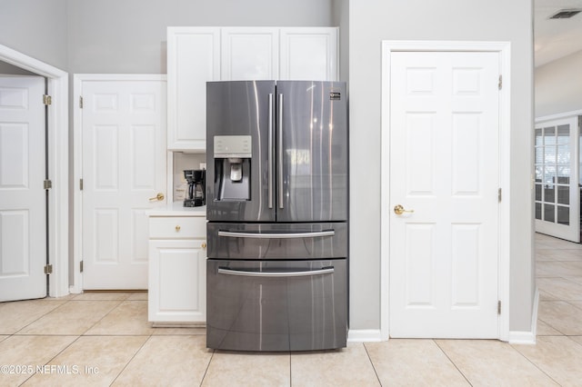 kitchen with white cabinetry, light tile patterned floors, and stainless steel refrigerator with ice dispenser