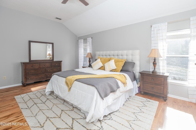 bedroom featuring ceiling fan, light hardwood / wood-style flooring, and lofted ceiling