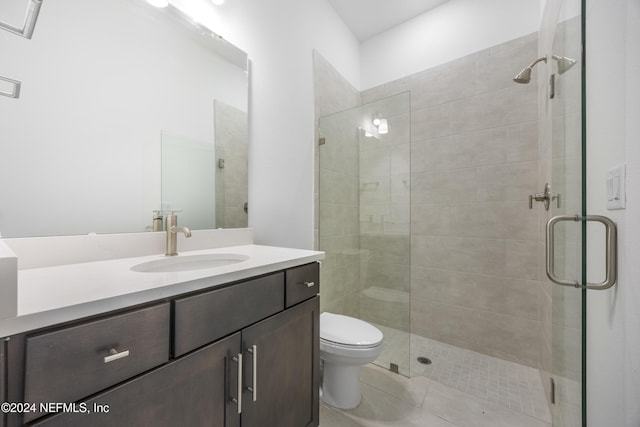 bathroom with vanity, toilet, and a shower with door