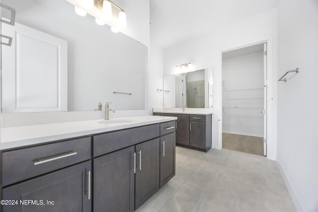 bathroom with a shower, vanity, and tile patterned floors