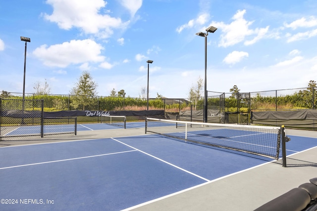 view of tennis court with basketball hoop