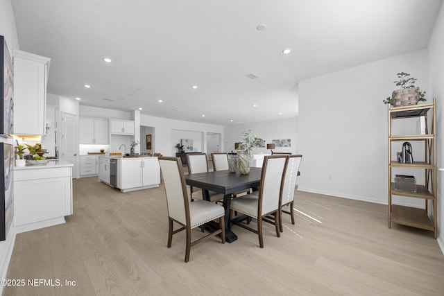 dining area with sink and light wood-type flooring