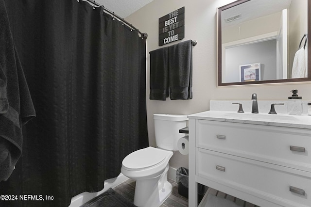 bathroom with vanity, a textured ceiling, hardwood / wood-style flooring, and toilet