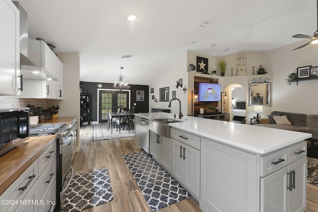 kitchen with appliances with stainless steel finishes, sink, white cabinets, hardwood / wood-style floors, and an island with sink