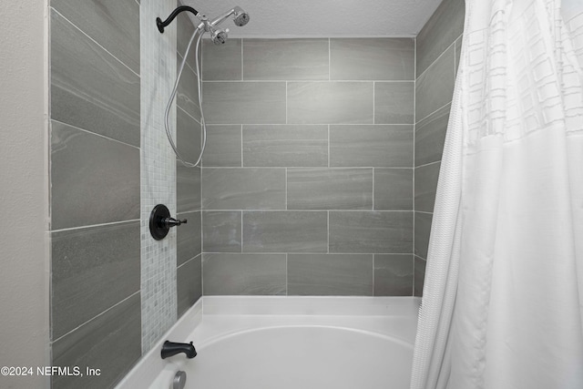 bathroom featuring shower / bath combo and a textured ceiling