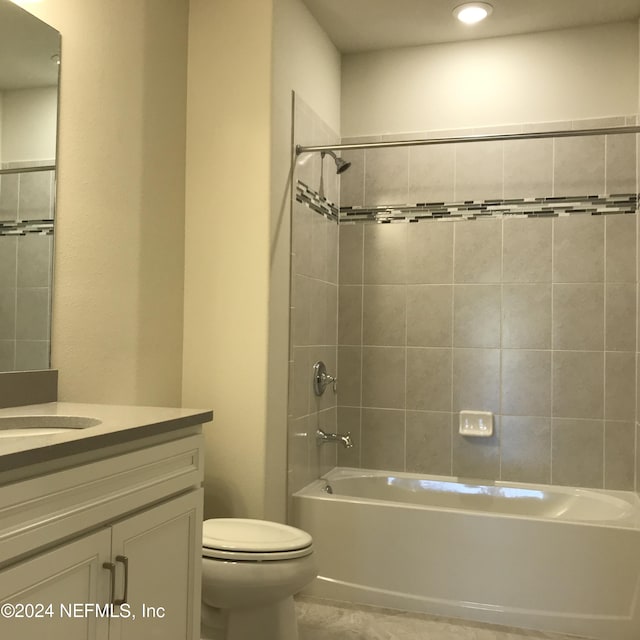 full bathroom featuring tile patterned floors, vanity, toilet, and tiled shower / bath