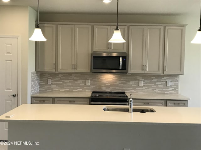 kitchen with pendant lighting, backsplash, sink, and stainless steel appliances