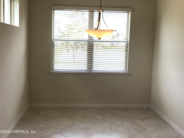 unfurnished dining area featuring a healthy amount of sunlight and light tile patterned floors