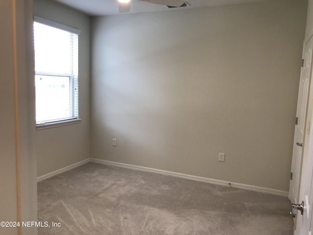 empty room featuring ceiling fan and light carpet