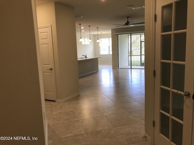 corridor with light tile patterned flooring and sink