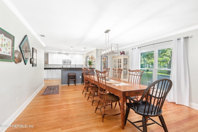 dining space with crown molding, ceiling fan, and light hardwood / wood-style floors