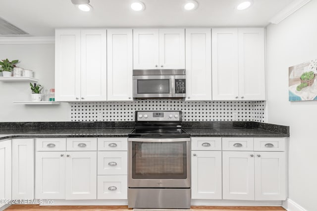 kitchen featuring appliances with stainless steel finishes, white cabinetry, and ornamental molding