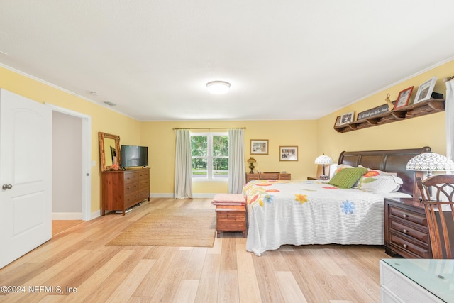 bedroom featuring hardwood / wood-style floors and crown molding