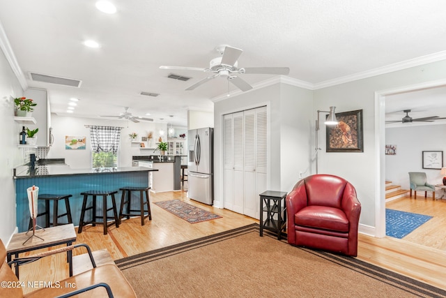 living room with light hardwood / wood-style floors and crown molding