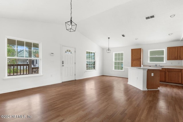 unfurnished living room featuring high vaulted ceiling, dark hardwood / wood-style floors, sink, and a wealth of natural light