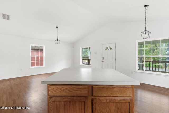 kitchen with a center island, hanging light fixtures, and vaulted ceiling