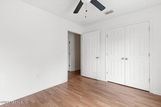 unfurnished bedroom with ceiling fan, light hardwood / wood-style flooring, and a closet