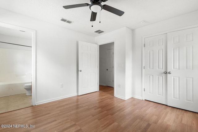 unfurnished bedroom with light hardwood / wood-style flooring, ensuite bath, and ceiling fan