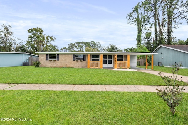 single story home featuring covered porch, a carport, cooling unit, and a front yard