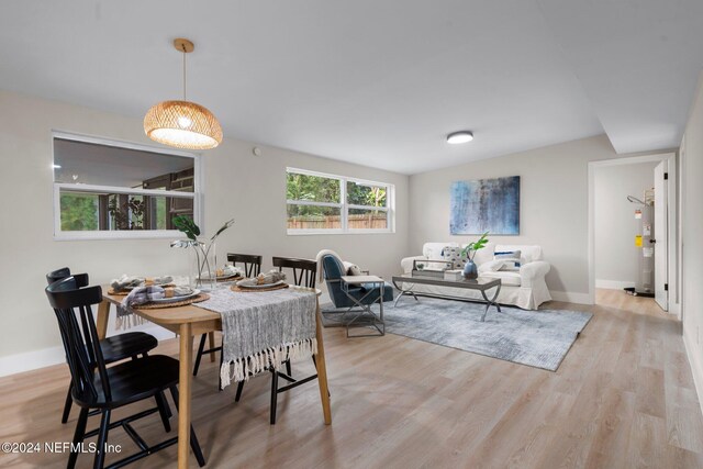 dining area with electric water heater and light wood-type flooring