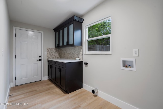 washroom featuring cabinets, washer hookup, and light hardwood / wood-style flooring