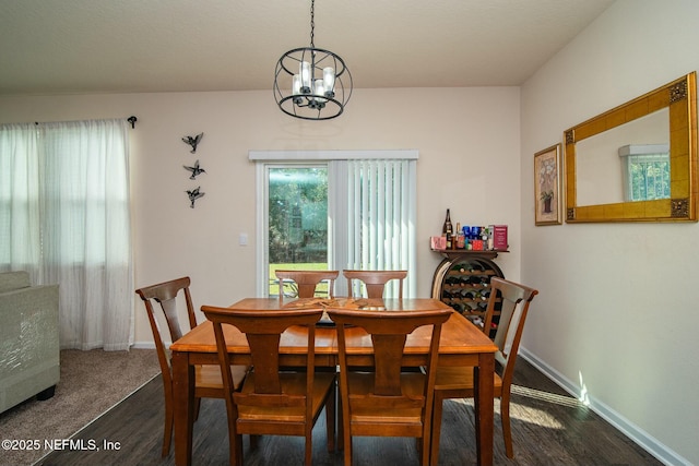 dining room with dark hardwood / wood-style flooring and a chandelier