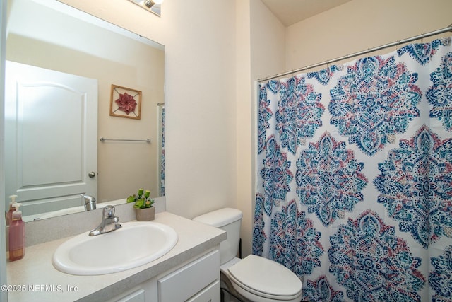 bathroom featuring a shower with shower curtain, vanity, and toilet