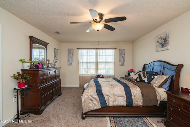 bedroom with ceiling fan, light carpet, and a textured ceiling