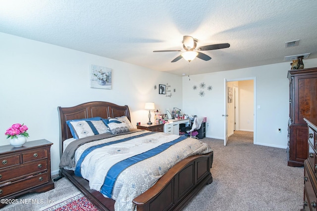 carpeted bedroom with ceiling fan and a textured ceiling