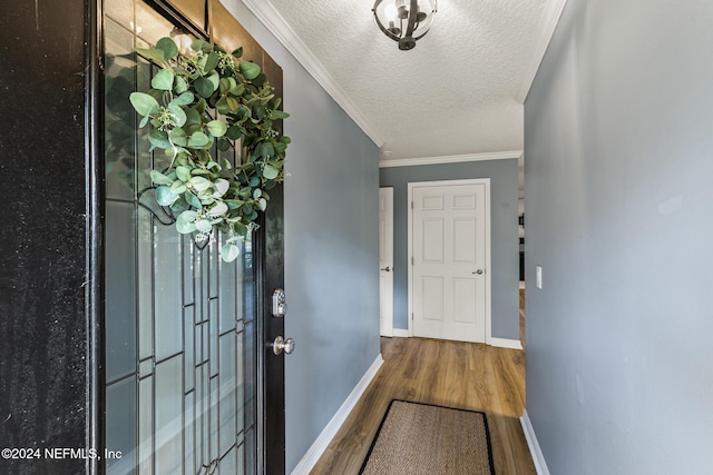 doorway to outside featuring crown molding, a textured ceiling, and hardwood / wood-style flooring