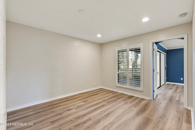 unfurnished room with light hardwood / wood-style flooring and crown molding