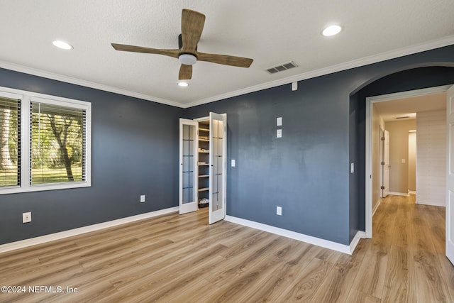 unfurnished bedroom featuring ceiling fan, light hardwood / wood-style flooring, crown molding, a textured ceiling, and a closet