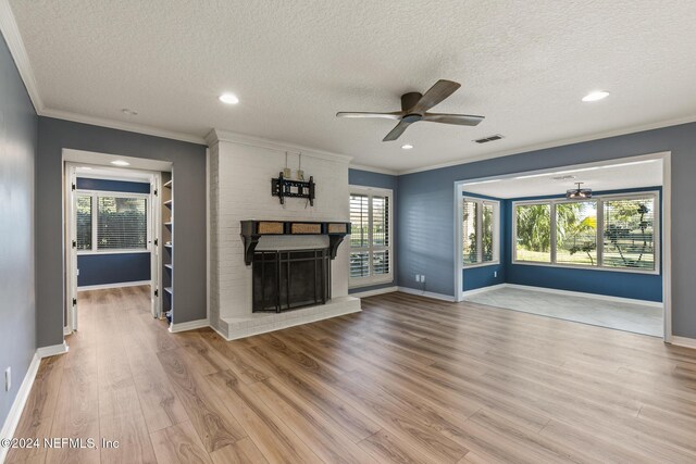 unfurnished living room with ceiling fan, ornamental molding, a textured ceiling, and light hardwood / wood-style flooring