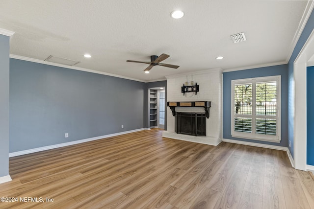 unfurnished living room with a fireplace, light hardwood / wood-style flooring, ceiling fan, and crown molding