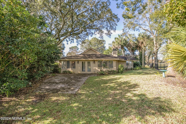 view of front of property with french doors and a front lawn