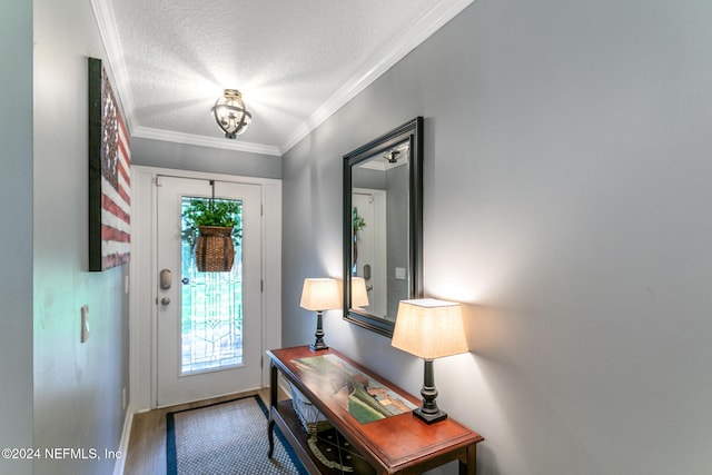 foyer entrance with ornamental molding, a textured ceiling, a healthy amount of sunlight, and hardwood / wood-style floors